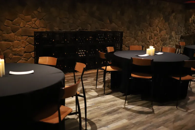 Dining tables with wine rack wall at Bella Vino